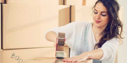 Lady packing her belongings in a box for storage